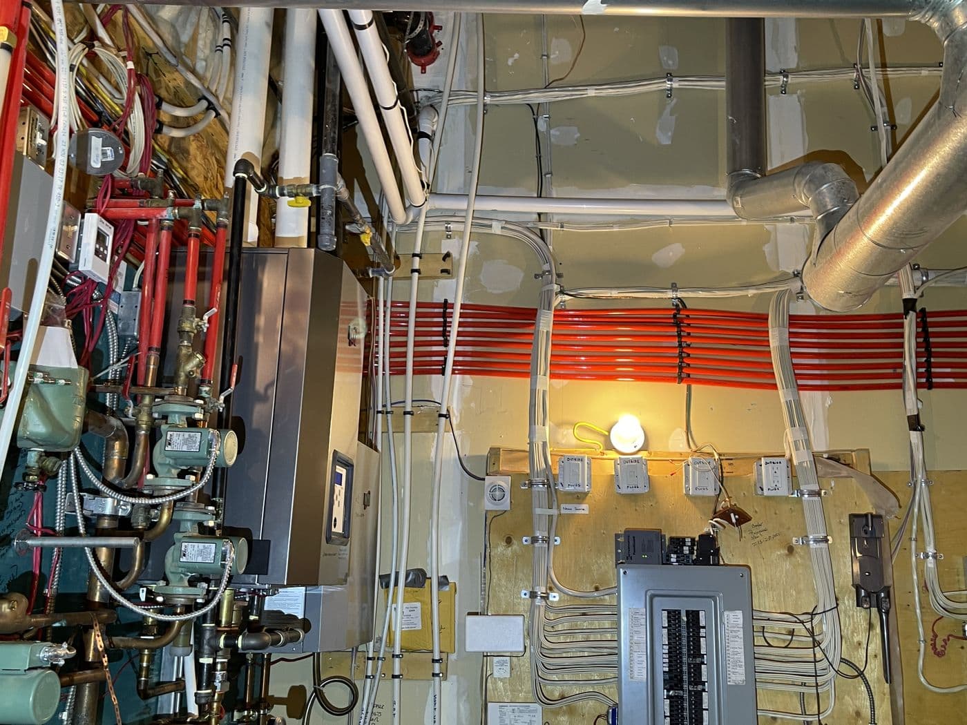 Large mechanical room with boilers, piping and electrical panels