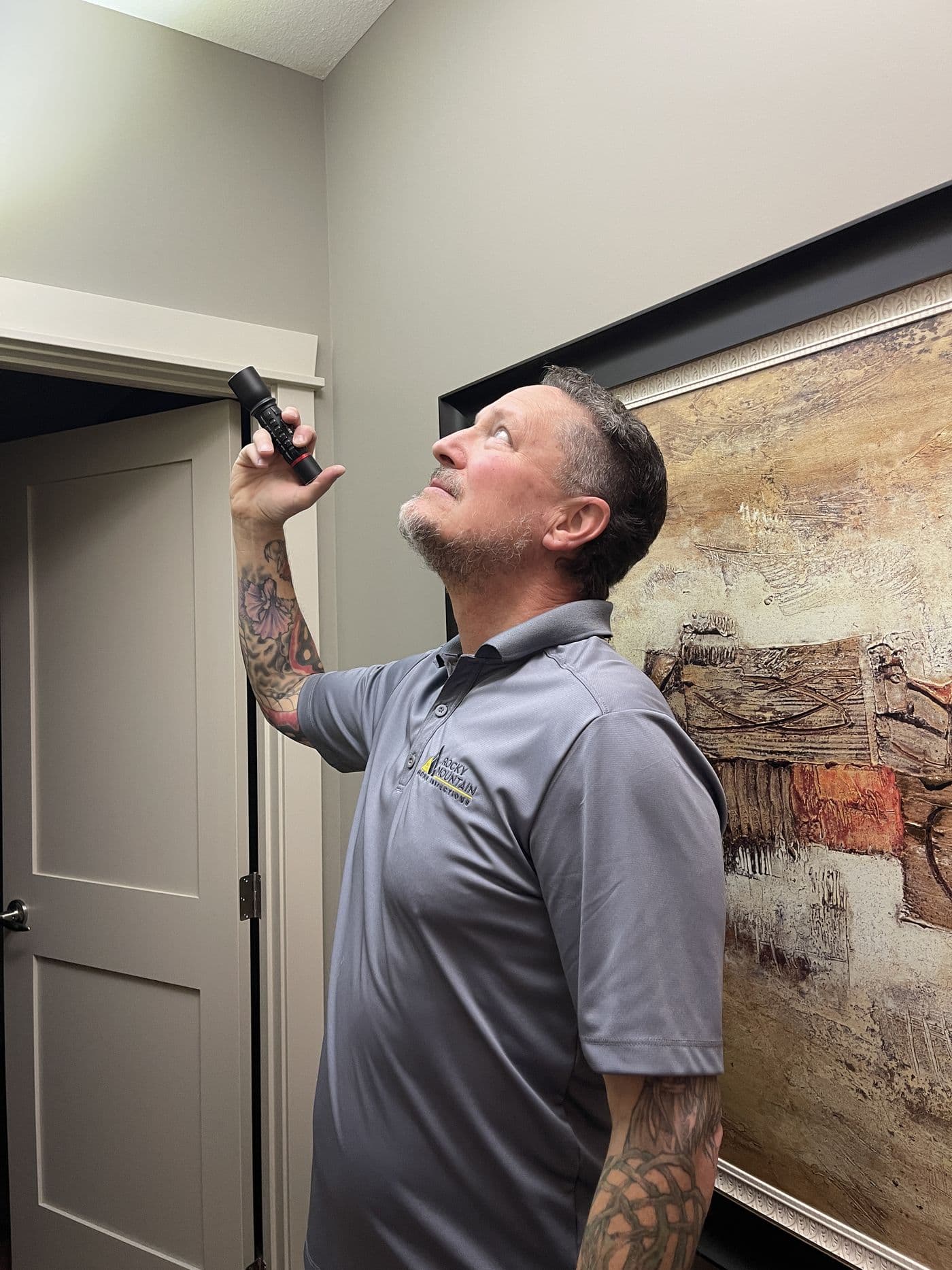 Kyle Dowdeswell checking a ceiling with a flashlight during a home inspection