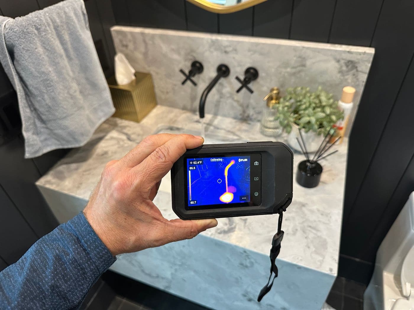 Thermal camera checking a bathroom vanity for hidden moisture