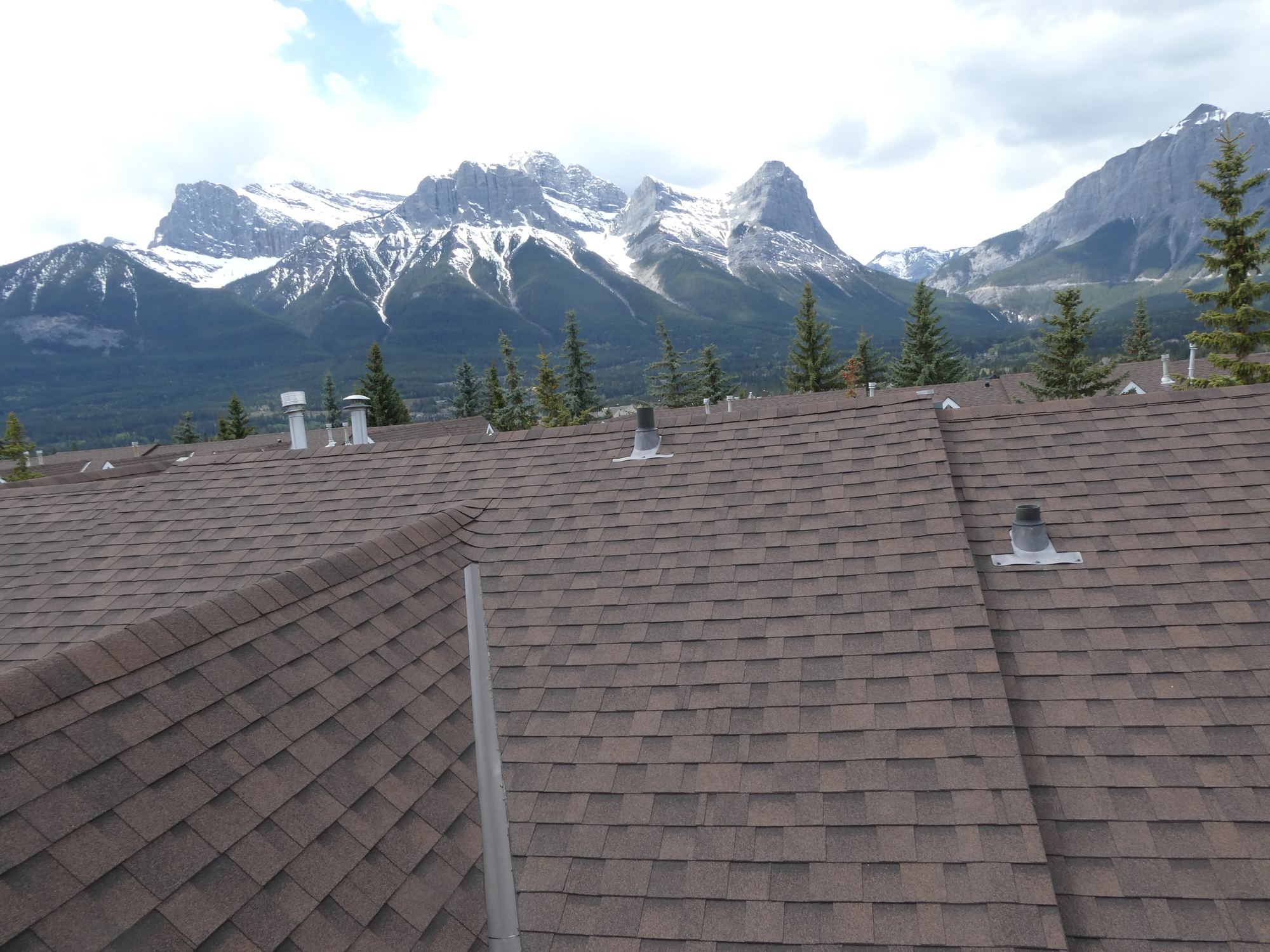Roof of a Canmore home with mountains behind